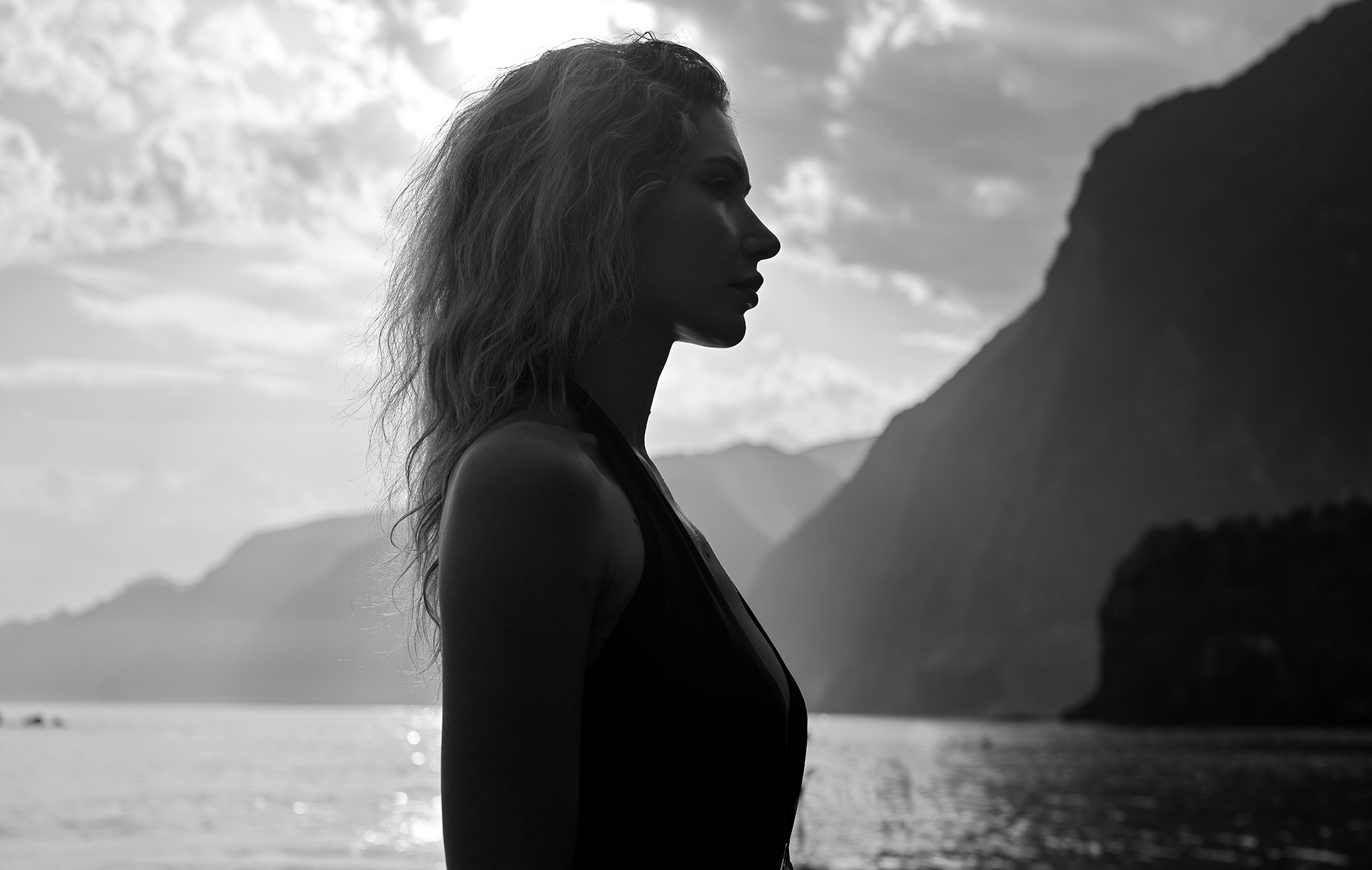Woman in profile against backlit mountains at Seixal, Madeira, black and white